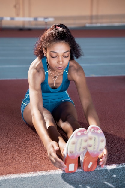 Free photo young woman stretching legs full shot