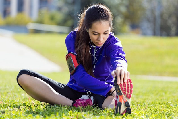 Foto gratuita giovane donna che si estende e si prepara per correre