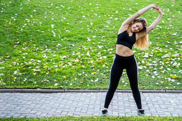 Young woman stretching at the street