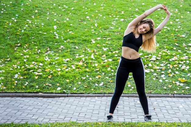 Young woman stretching at the street