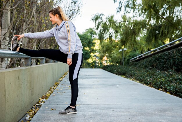 Young woman stretching at the street