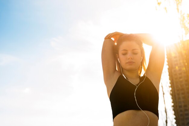 Young woman stretching at the street