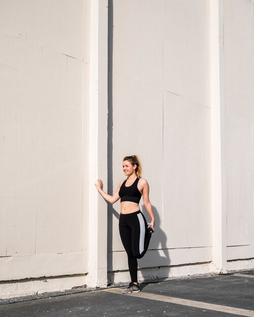 Young woman stretching at the street