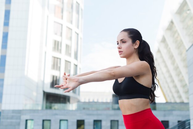 Young woman stretching in the street