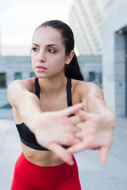 Young woman stretching in the street