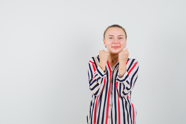 Young woman in striped blouse rejoicing and smiling and looking joyful