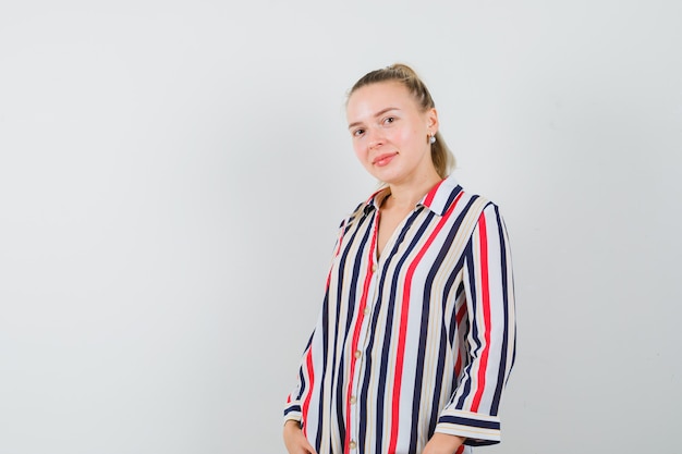 Free photo young woman in striped blouse and smiling and looking happy