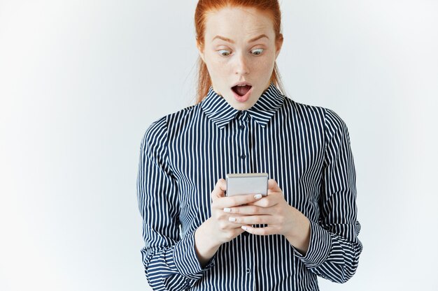 Young woman in striped shirt using smartphone