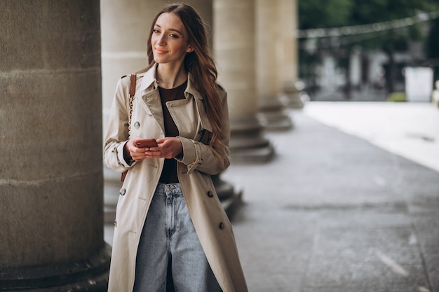 Young woman student by the university talking on the phone