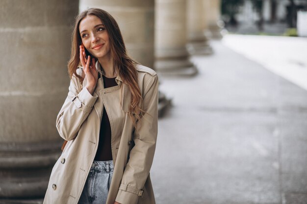 Young woman student by the university talking on the phone