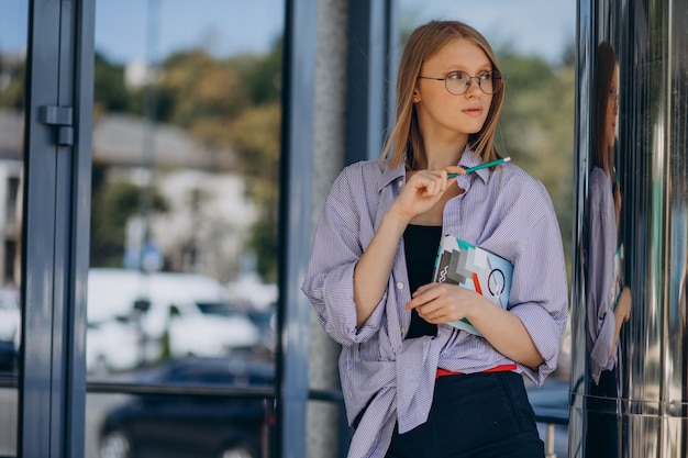 ノートブックを持つ若い女性学生