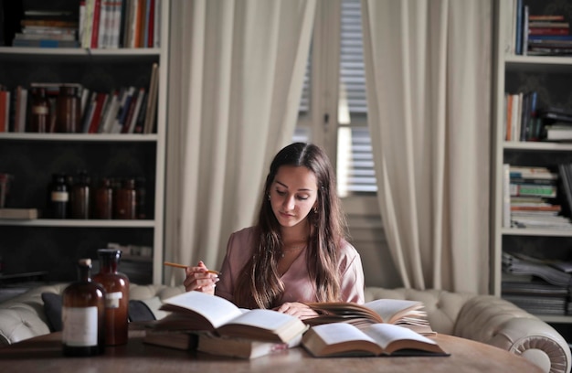 La giovane donna studia sui libri a casa