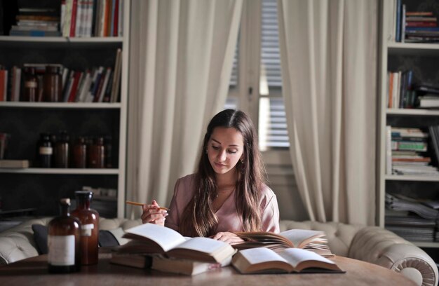 молодая женщина учится дома по книгам