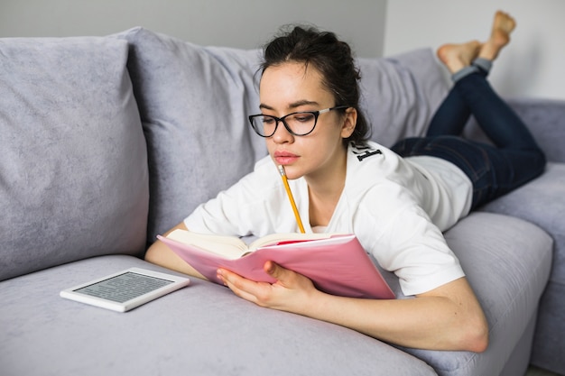 ソファーで勉強中の若い女性