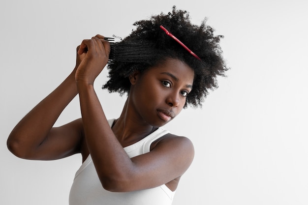 Young woman styling hair medium shot