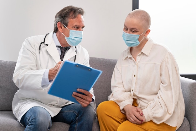 Free photo young woman suffering of breast cancer talking with her doctor