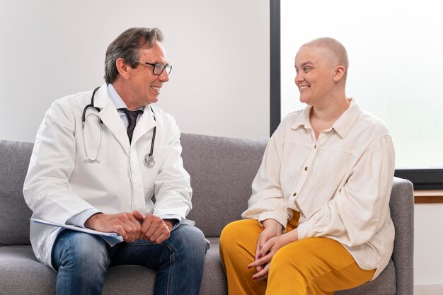 Young woman suffering of breast cancer talking with her doctor