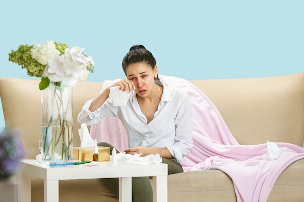 집안 먼지나 계절 알레르기로 고통받는 젊은 여성