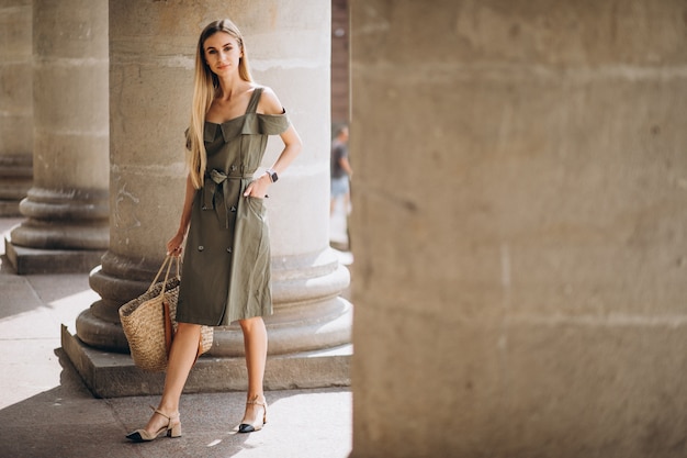 Foto gratuita giovane donna in abito estivo da un vecchio edificio