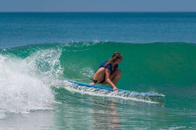 young woman surfing on the beach