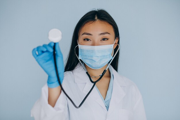 Молодая женщина-хирург на синем фоне со стетоскопом