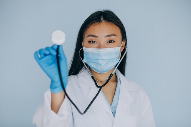 Young woman surgeon on blue background with stethoscope