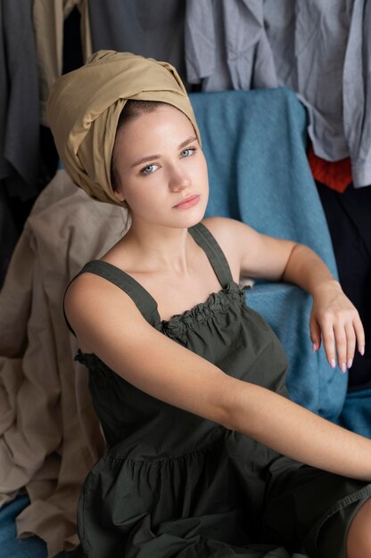 Молодая женщина в окружении груды одежды