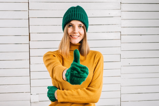 Foto gratuita giovane donna in maglione che mostra pollice in su