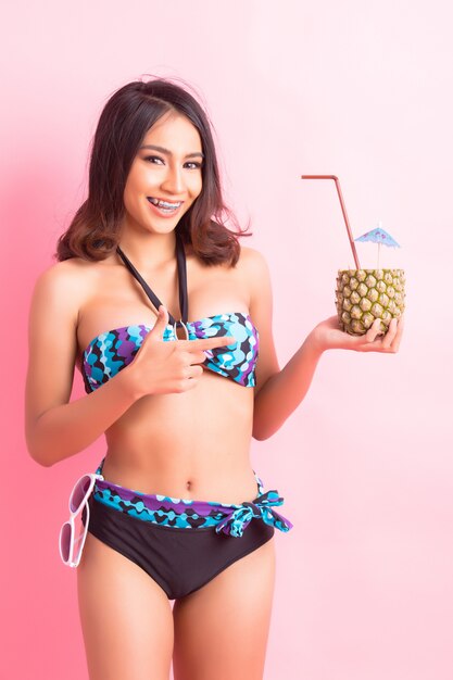 young woman in swimwear isolated over pink