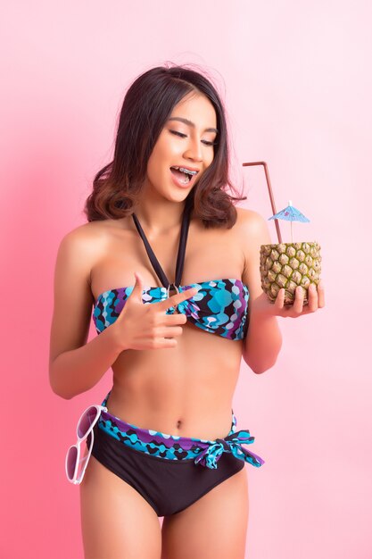 young woman in swimwear isolated over pink