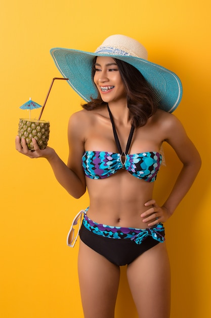 young woman in swimwear isolated over yellow