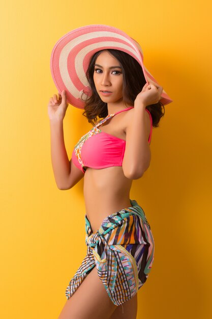 young woman in swimwear isolated over yellow