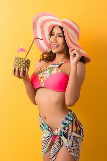 Free photo young woman in swimwear isolated over yellow