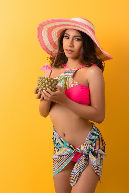 young woman in swimwear isolated over yellow