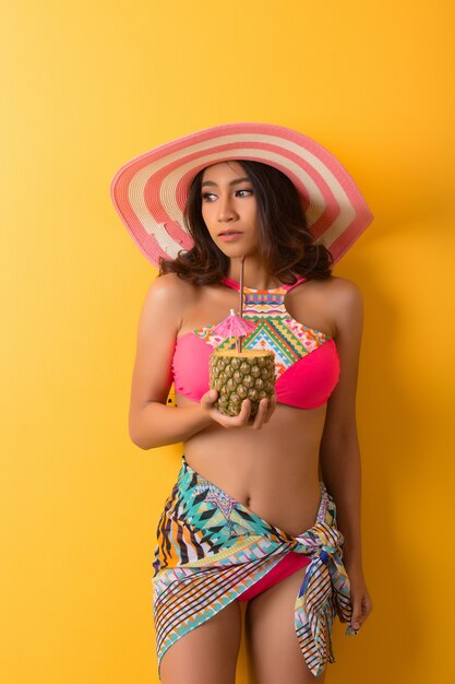 young woman in swimwear isolated over yellow