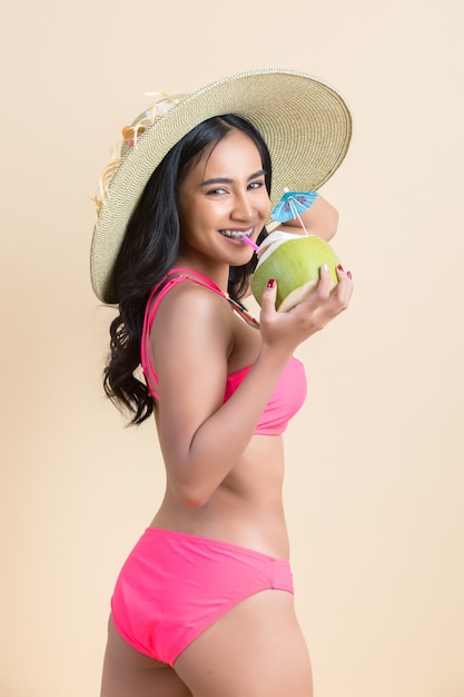 young woman in swimwear with coconut