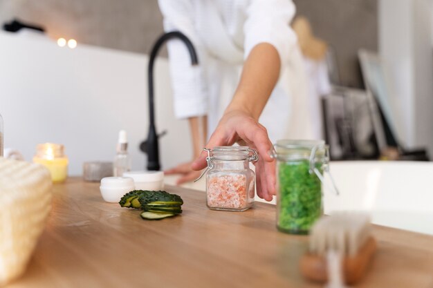 Young woman taking the bath salt to put some in the water before taking a bath