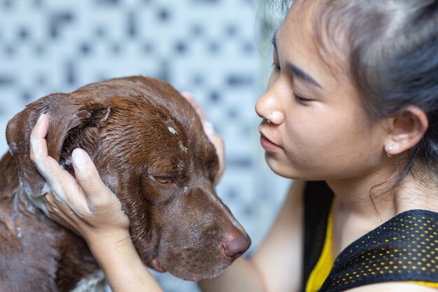 Young woman taking a bath with her favorite dog, world dog love day concept.