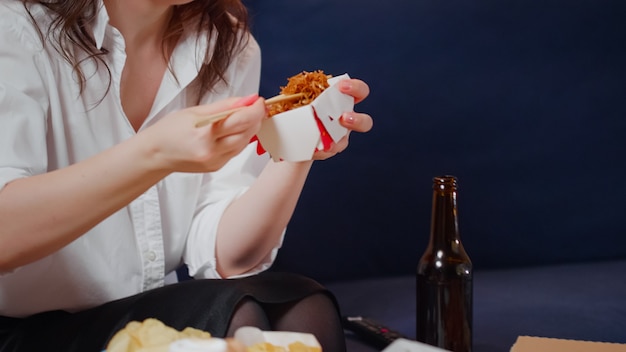 Young woman taking box of chinese food from table