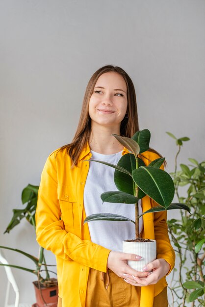 녹색 식물을 돌보는 젊은 여자