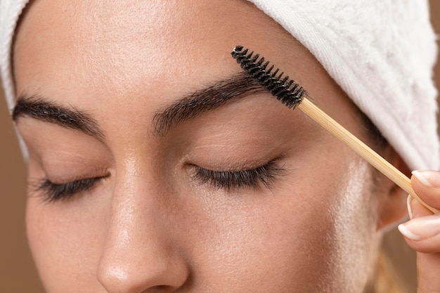 Young woman taking care of her eyebrows