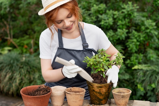 Young woman taking care of her plants in a greenhouse