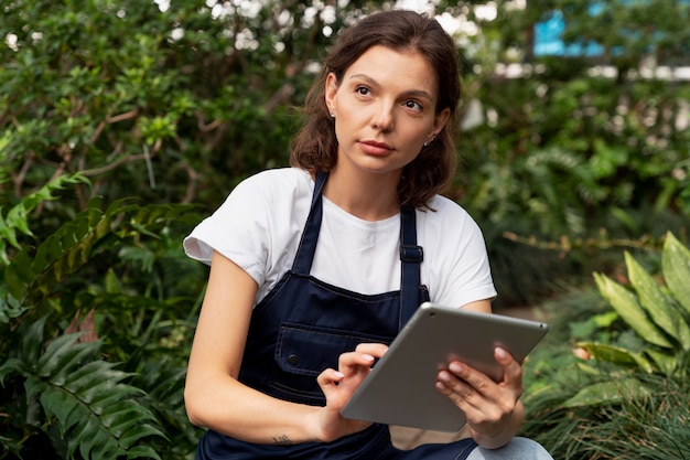 温室で彼女の植物の世話をしている若い女性