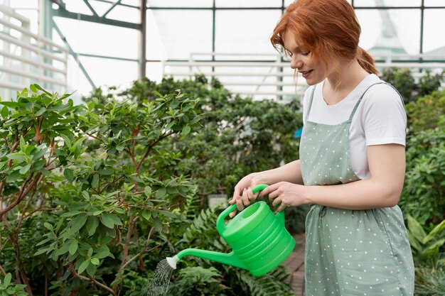 彼女の植物の世話をする若い女性