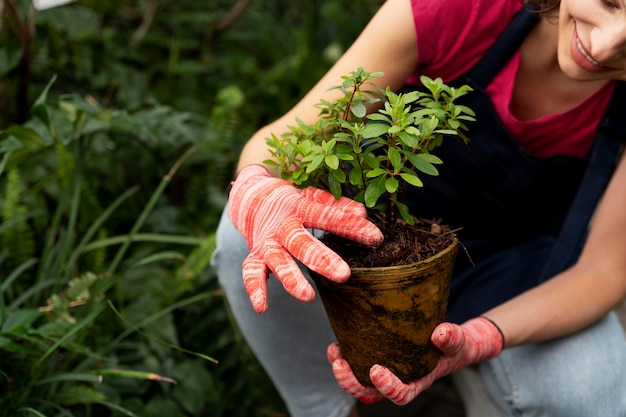 彼女の植物の世話をする若い女性