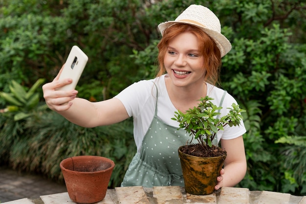 Free photo young woman taking care of her plants