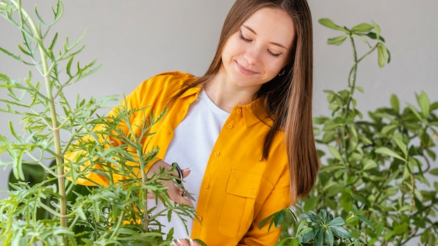 無料写真 緑の植物の世話をする若い女性