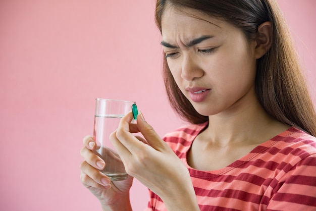 Young woman taking medicine pill after doctor order