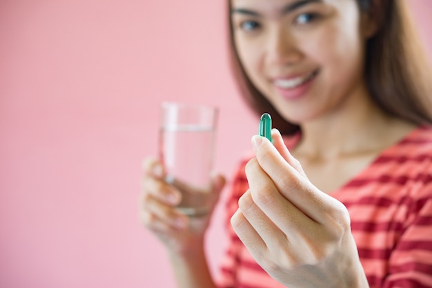 Young woman taking medicine pill after doctor order