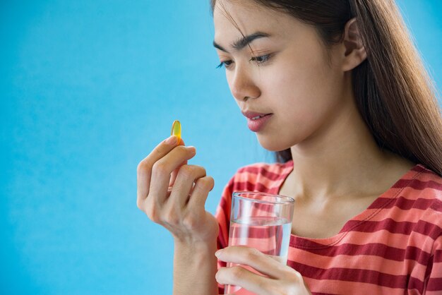 医師の指示の後の薬を飲んで若い女性